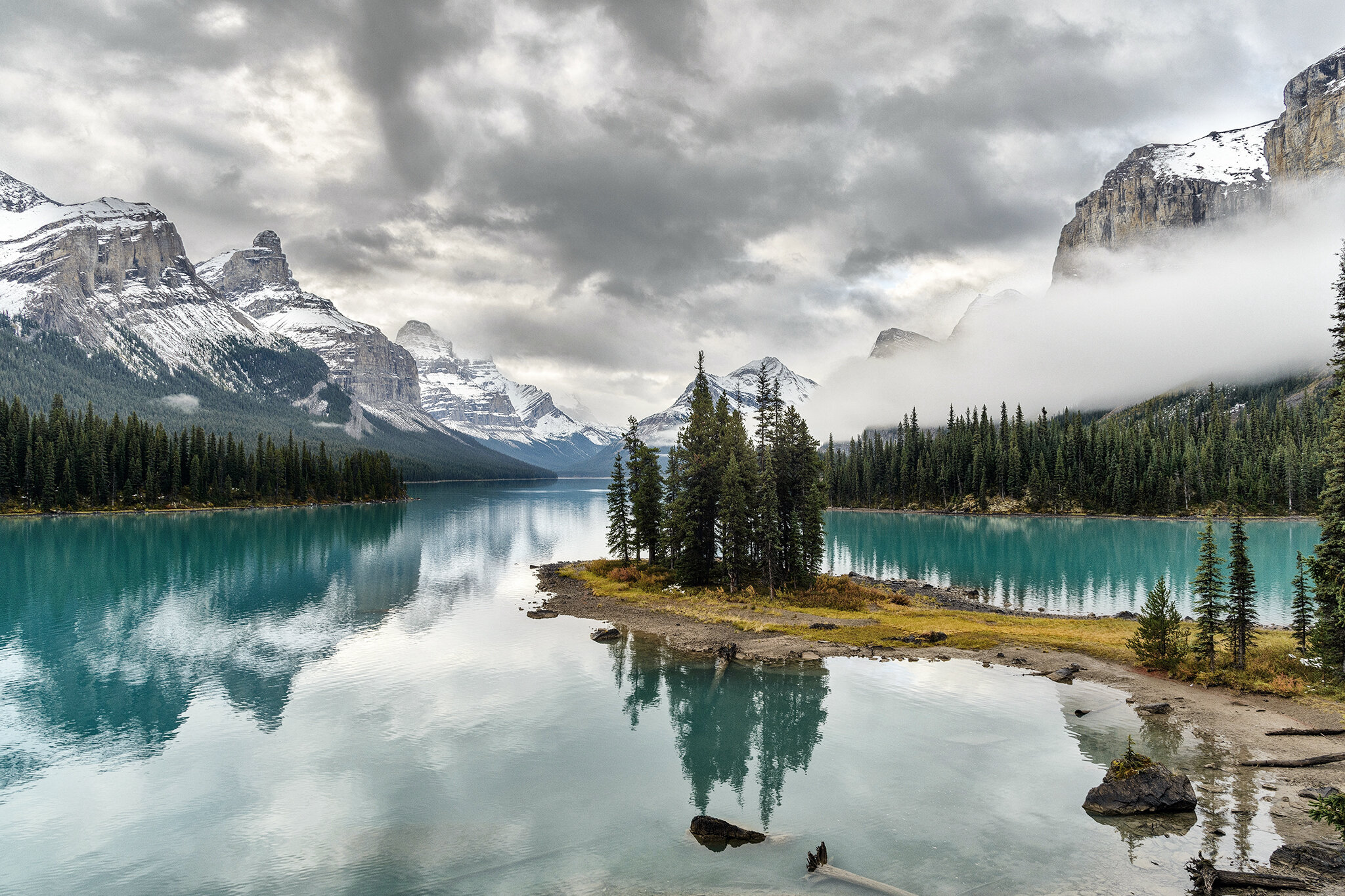 Blick auf den Maligne Lake, ein See im Jasper-Nationalpark in der kanadischen Provinz Alberta mit bewölkter Bergkulisse im Hintergrund. | © unsplash | Sergey Pesterev