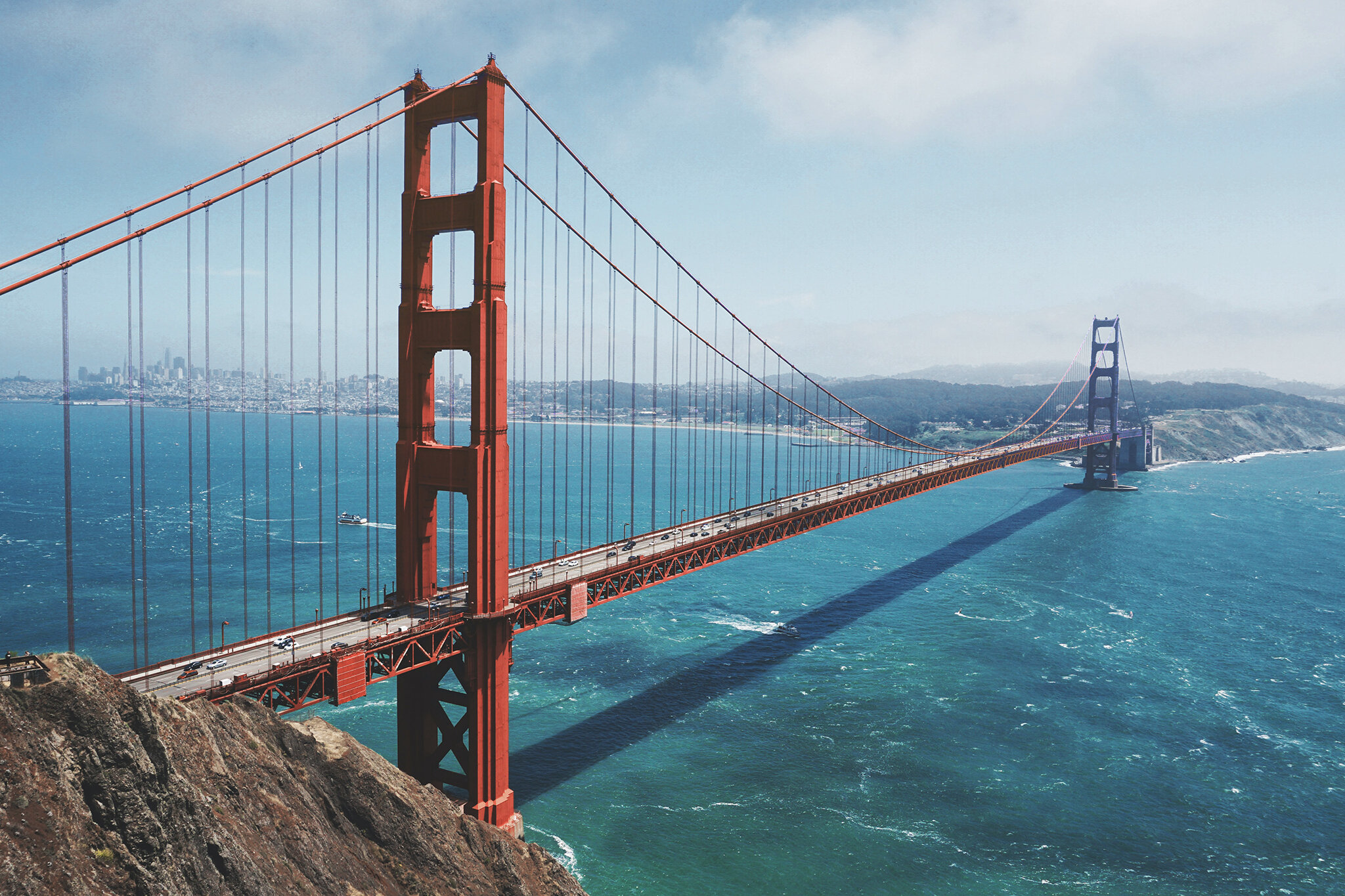 In einer perspektivischen Aufnahme sieht man wie sich die Golden Gate Hängebrücke von San Francisco, USA von einem Ufer zum anderen spannt. | © unsplash | Maarten van den Heuvel